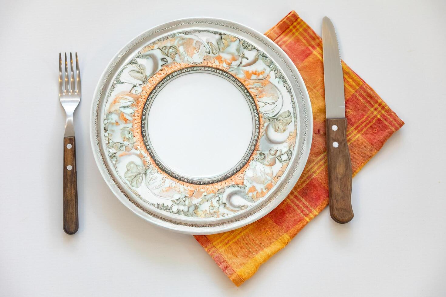 Empty plate top view with metal cutlery next to it photo