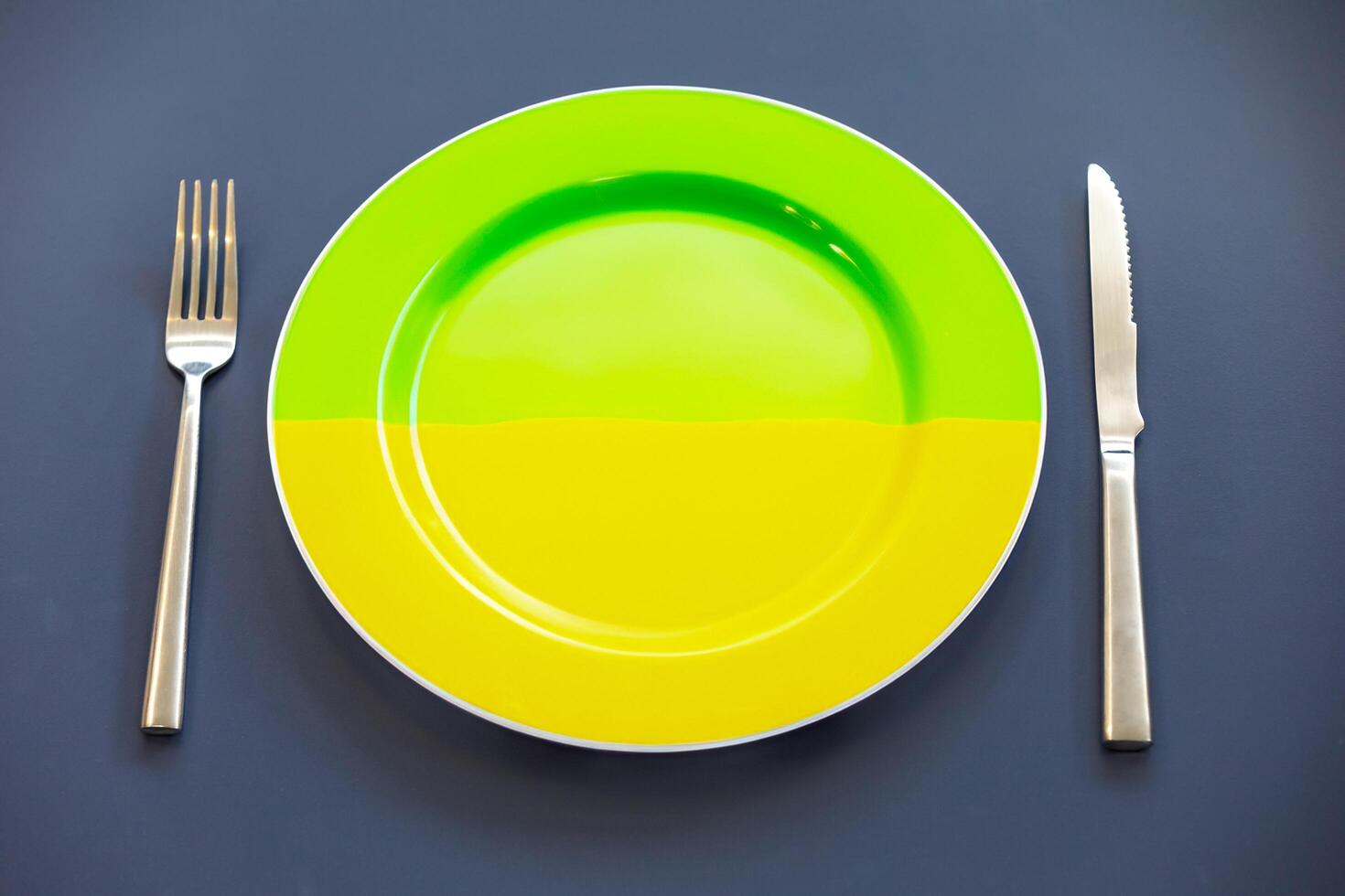 Empty plate top view with metal cutlery next to it photo