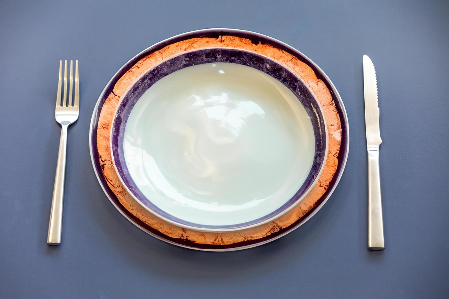 Empty plate top view with metal cutlery next to it photo