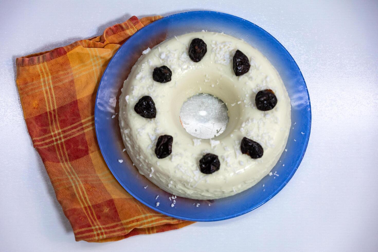 Traditional Brazilian coconut flan dessert known as manjar branco, manjar de coco and manjar dos deuses. Served with plum syrup. photo