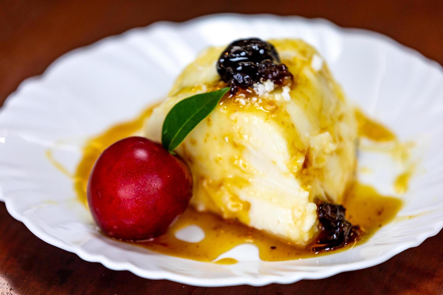 Traditional Brazilian coconut flan dessert known as manjar branco, manjar de coco and manjar dos deuses. Served with plum syrup. photo