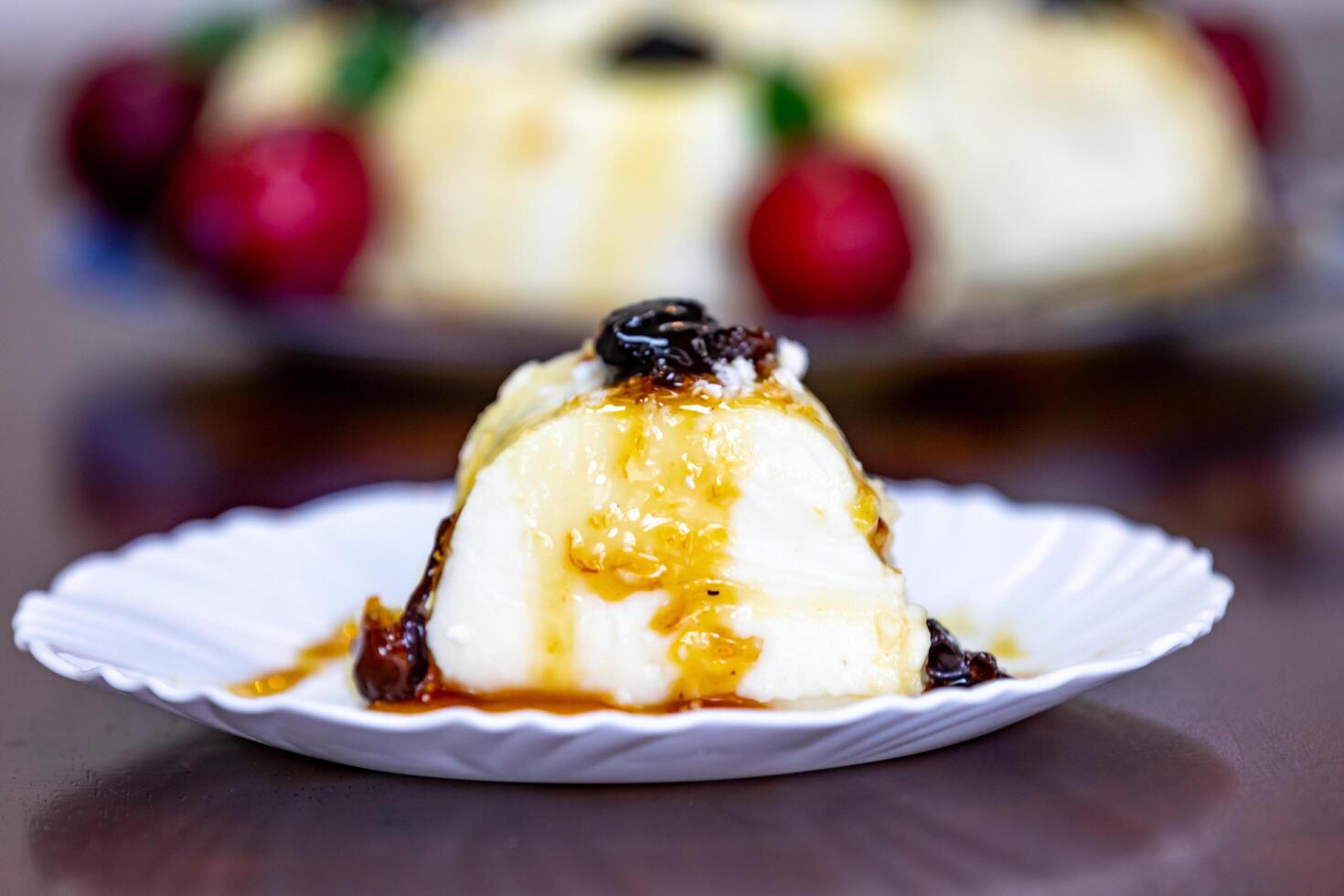 Traditional Brazilian coconut flan dessert known as manjar branco, manjar de coco and manjar dos deuses. Served with plum syrup. photo