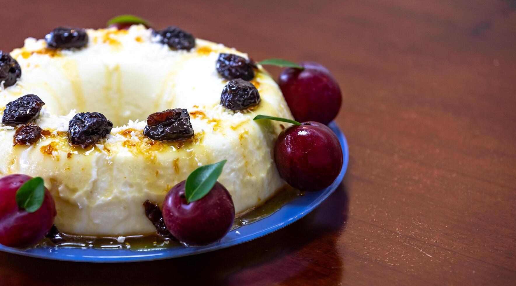 Traditional Brazilian coconut flan dessert known as manjar branco, manjar de coco and manjar dos deuses. Served with plum syrup. photo