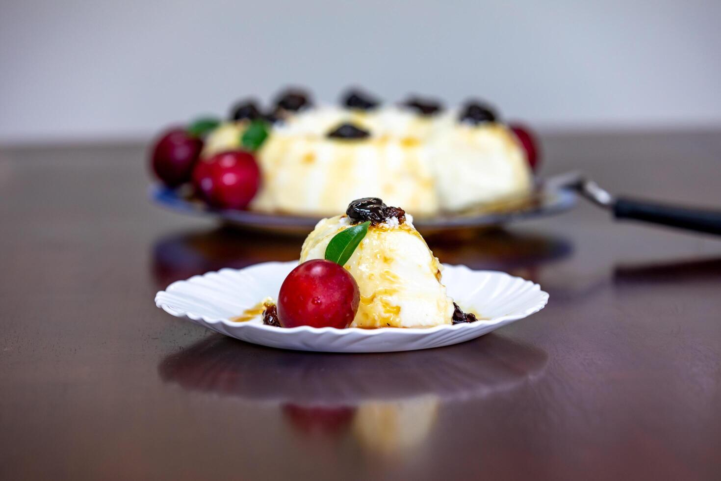 Traditional Brazilian coconut flan dessert known as manjar branco, manjar de coco and manjar dos deuses. Served with plum syrup. photo