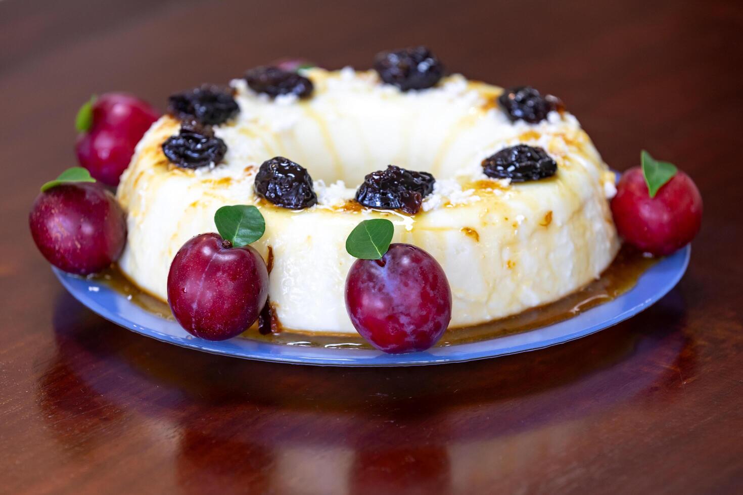 Traditional Brazilian coconut flan dessert known as manjar branco, manjar de coco and manjar dos deuses. Served with plum syrup. photo