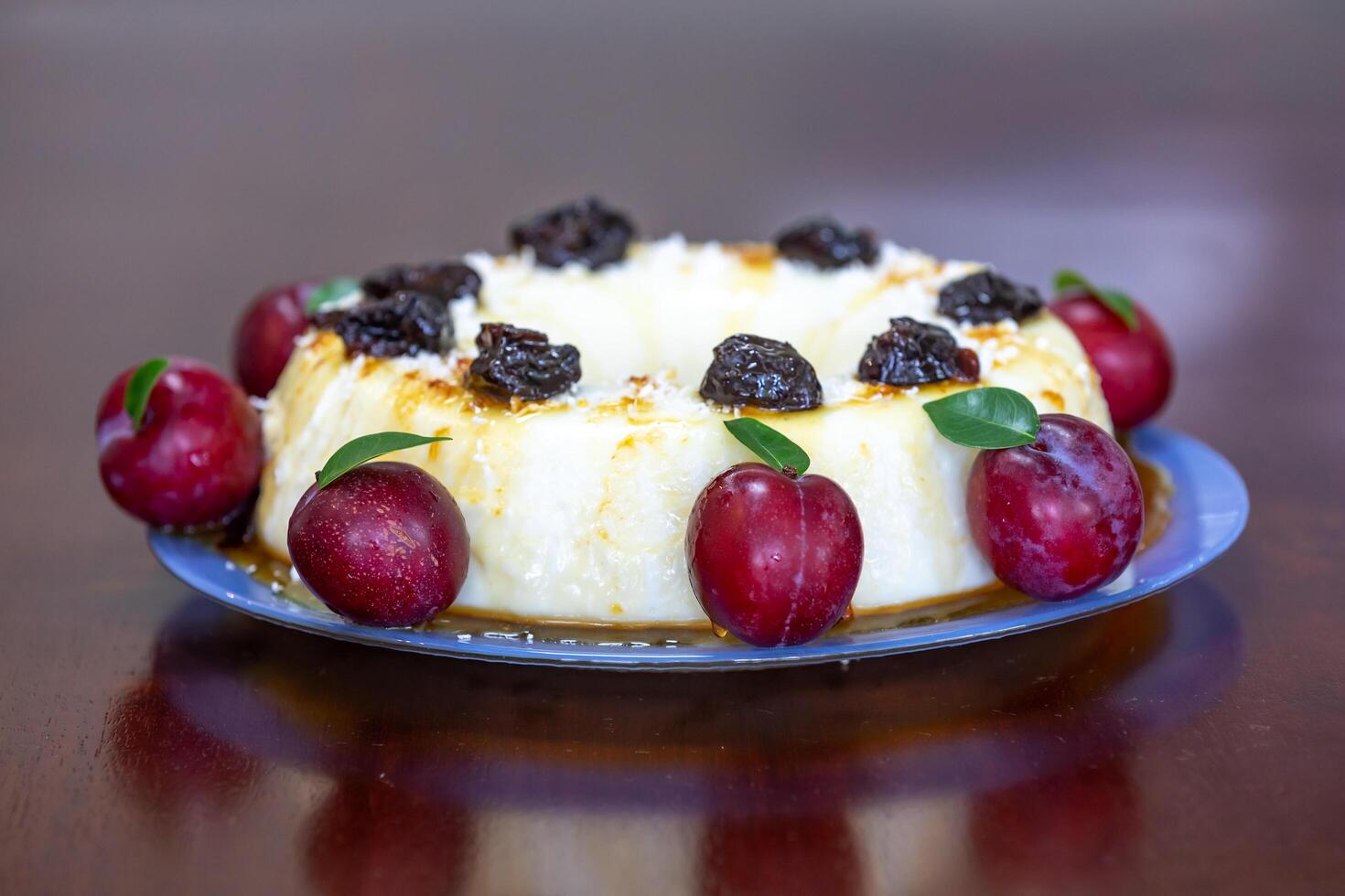 Traditional Brazilian coconut flan dessert known as manjar branco, manjar de coco and manjar dos deuses. Served with plum syrup. photo