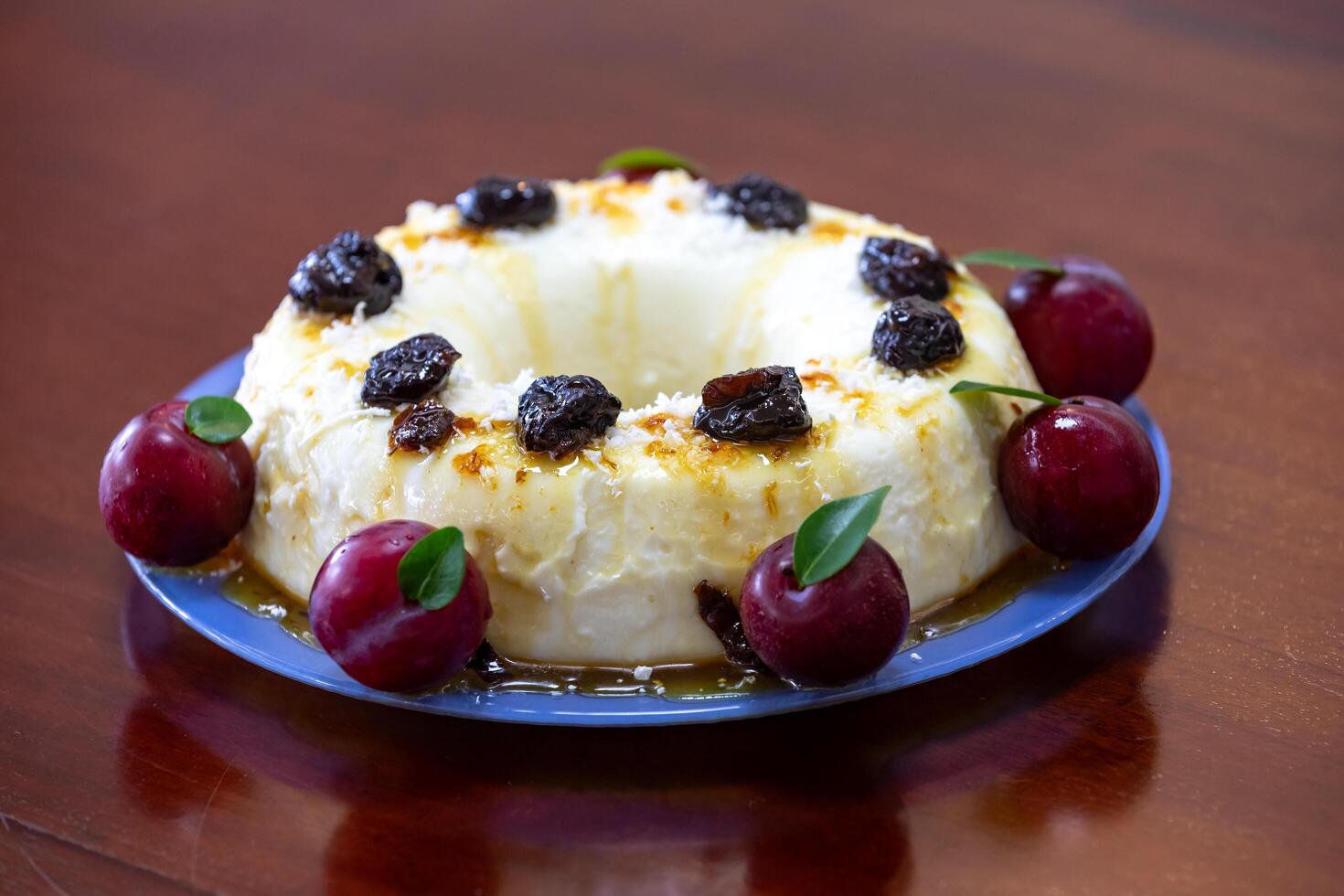 Traditional Brazilian coconut flan dessert known as manjar branco, manjar de coco and manjar dos deuses. Served with plum syrup. photo