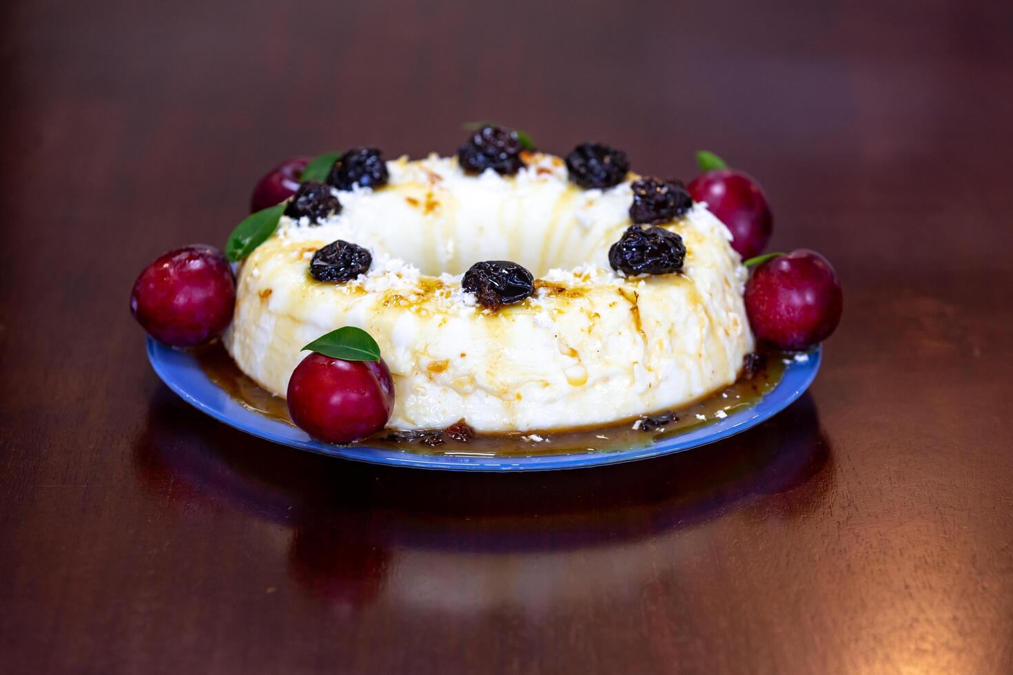 Traditional Brazilian coconut flan dessert known as manjar branco, manjar de coco and manjar dos deuses. Served with plum syrup. photo