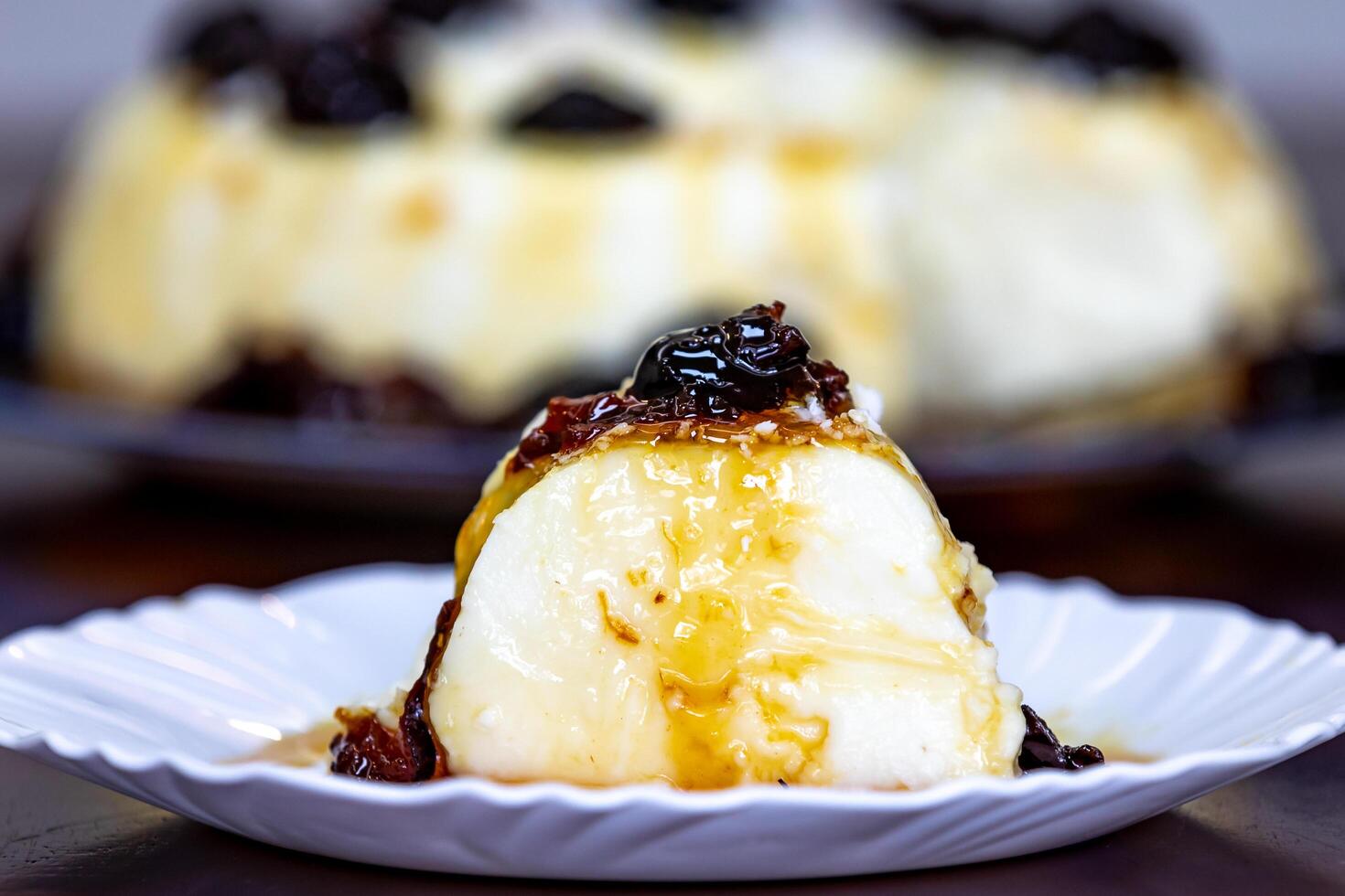 Traditional Brazilian coconut flan dessert known as manjar branco, manjar de coco and manjar dos deuses. Served with plum syrup. photo