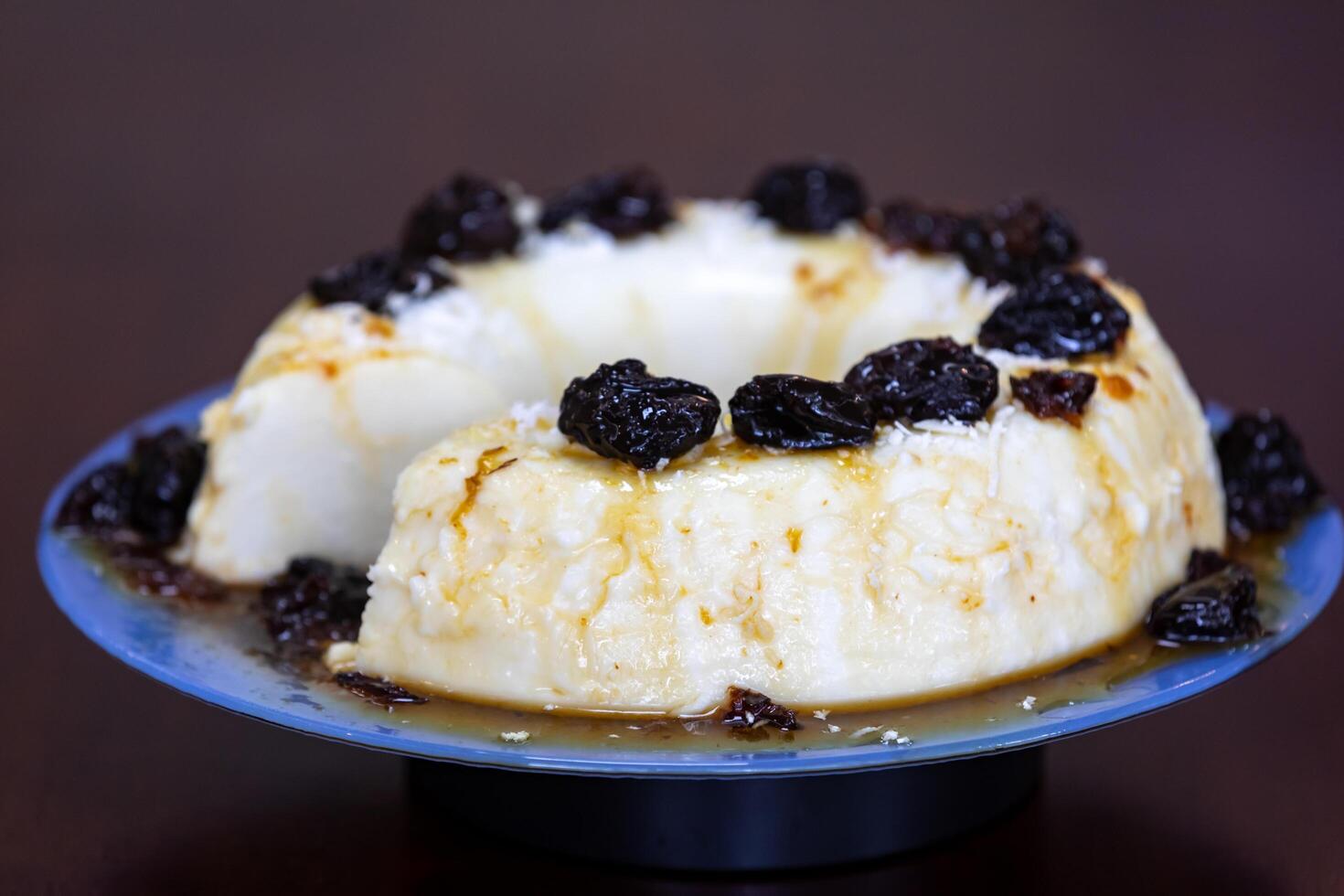 Traditional Brazilian coconut flan dessert known as manjar branco, manjar de coco and manjar dos deuses. Served with plum syrup. photo
