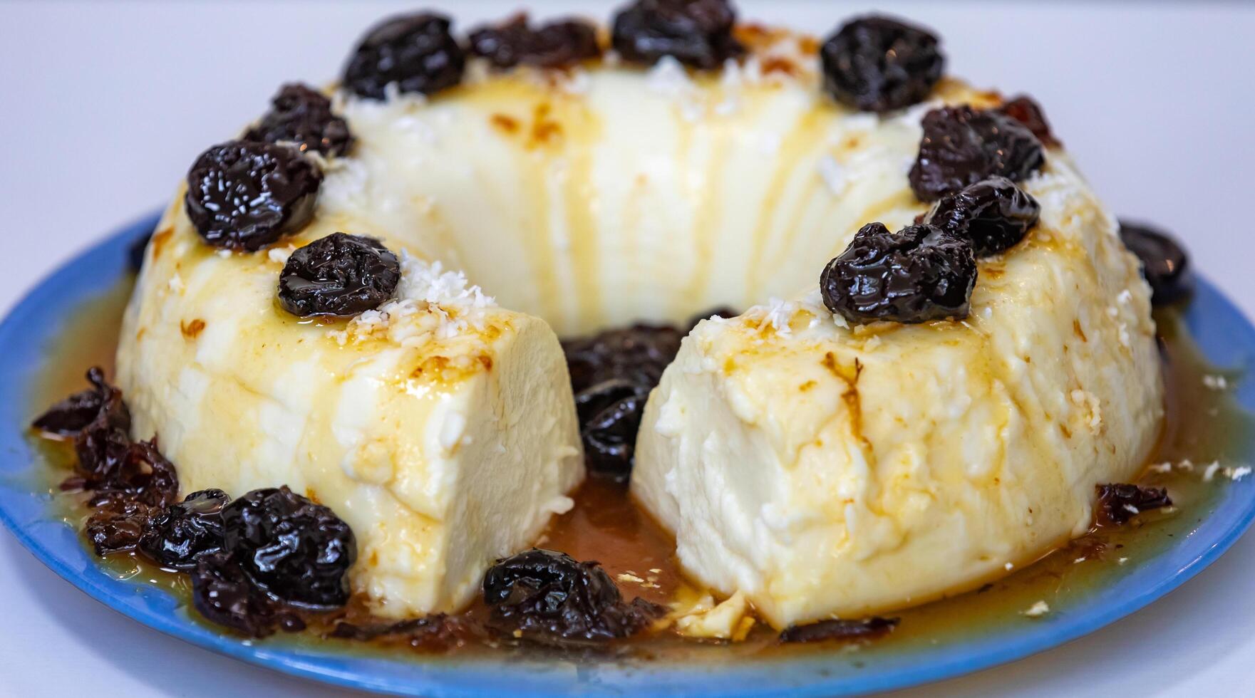 Traditional Brazilian coconut flan dessert known as manjar branco, manjar de coco and manjar dos deuses. Served with plum syrup. photo
