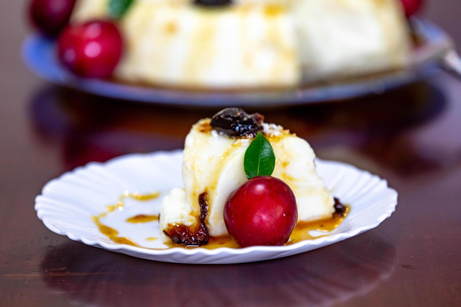 Traditional Brazilian coconut flan dessert known as manjar branco, manjar de coco and manjar dos deuses. Served with plum syrup. photo