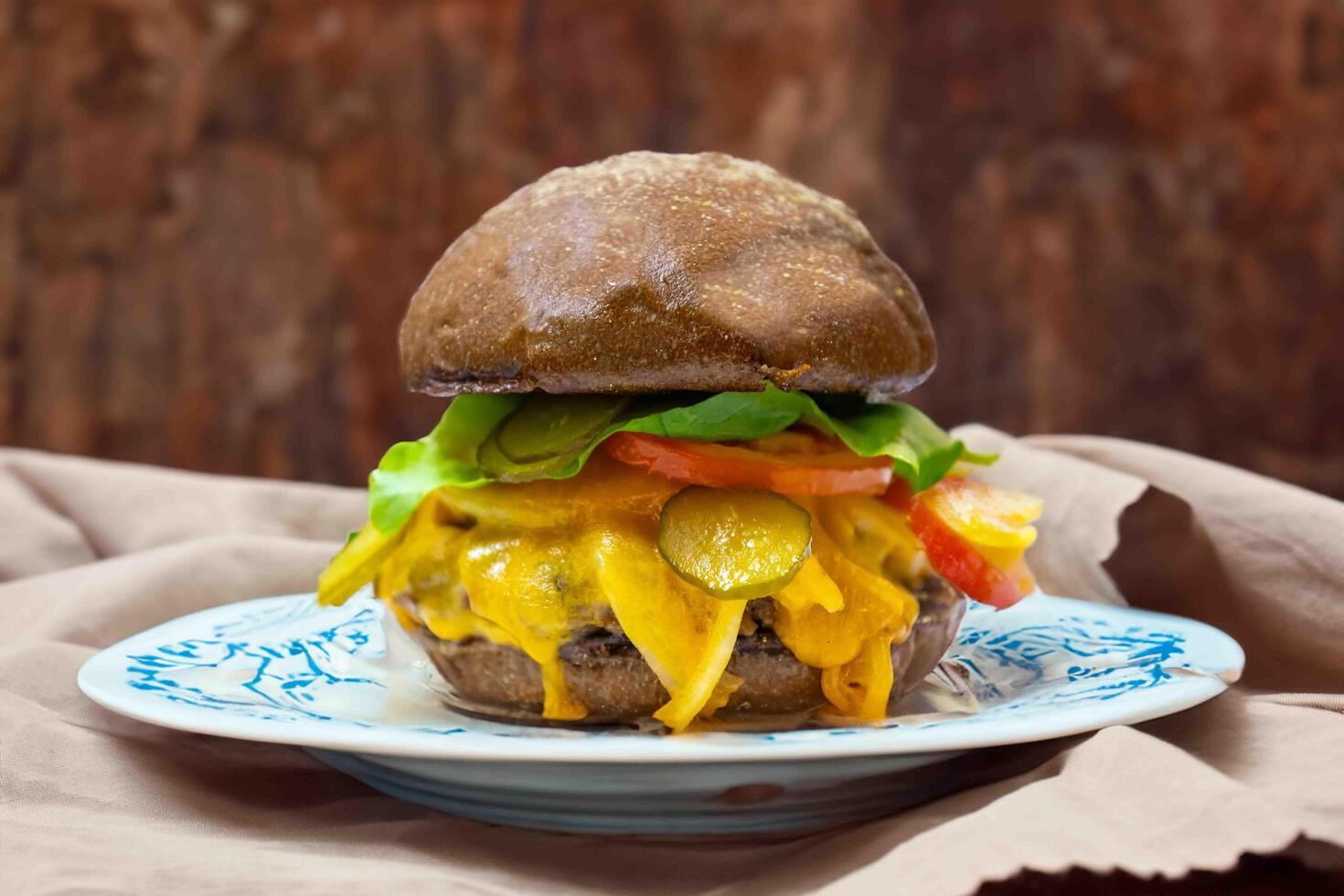 Traditional rustic burger sandwich with cheddar cheese, vegetables and Australian bread in creative photography and cozy village setting photo