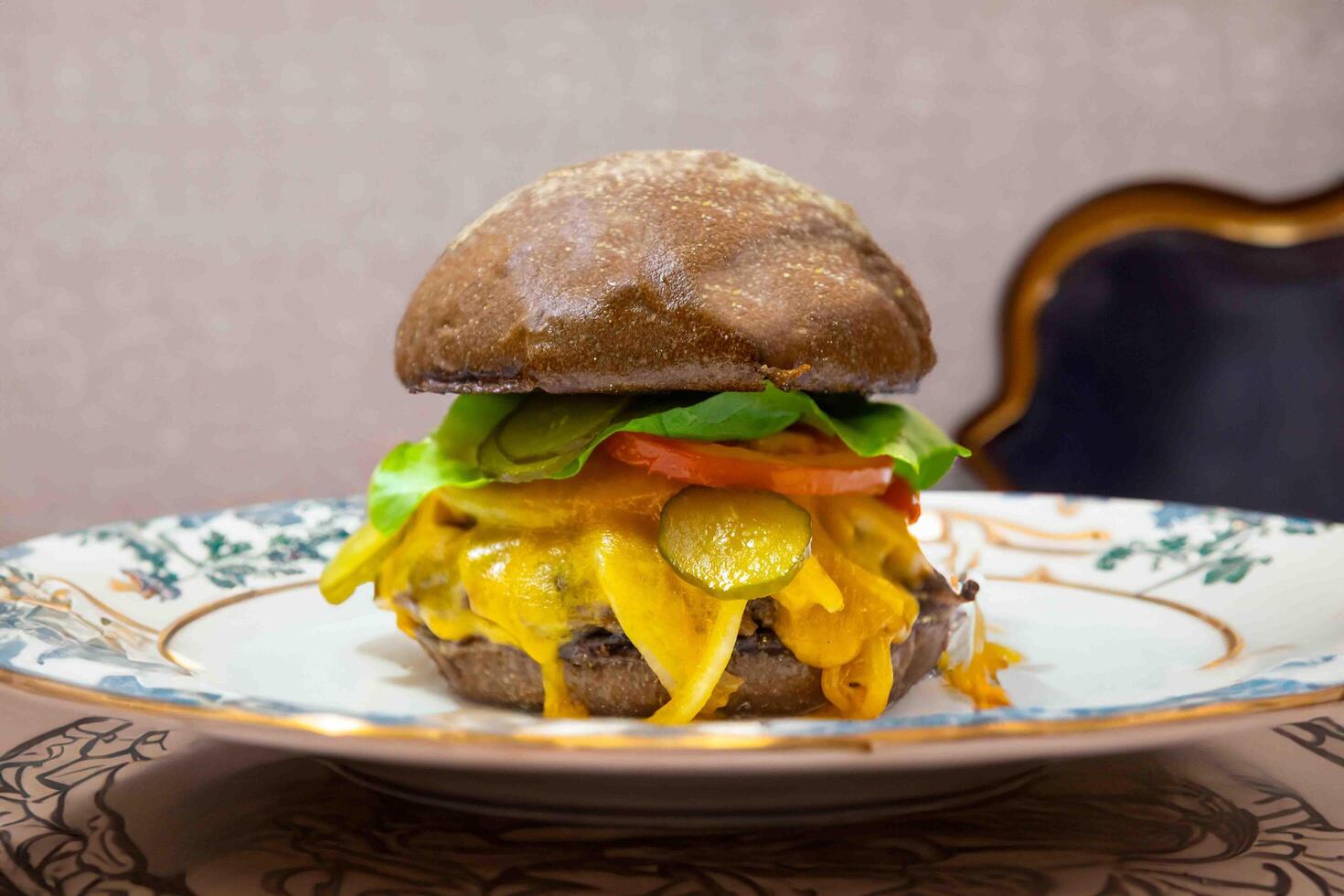 Traditional rustic burger sandwich with cheddar cheese, vegetables and Australian bread in creative photography and cozy village setting photo