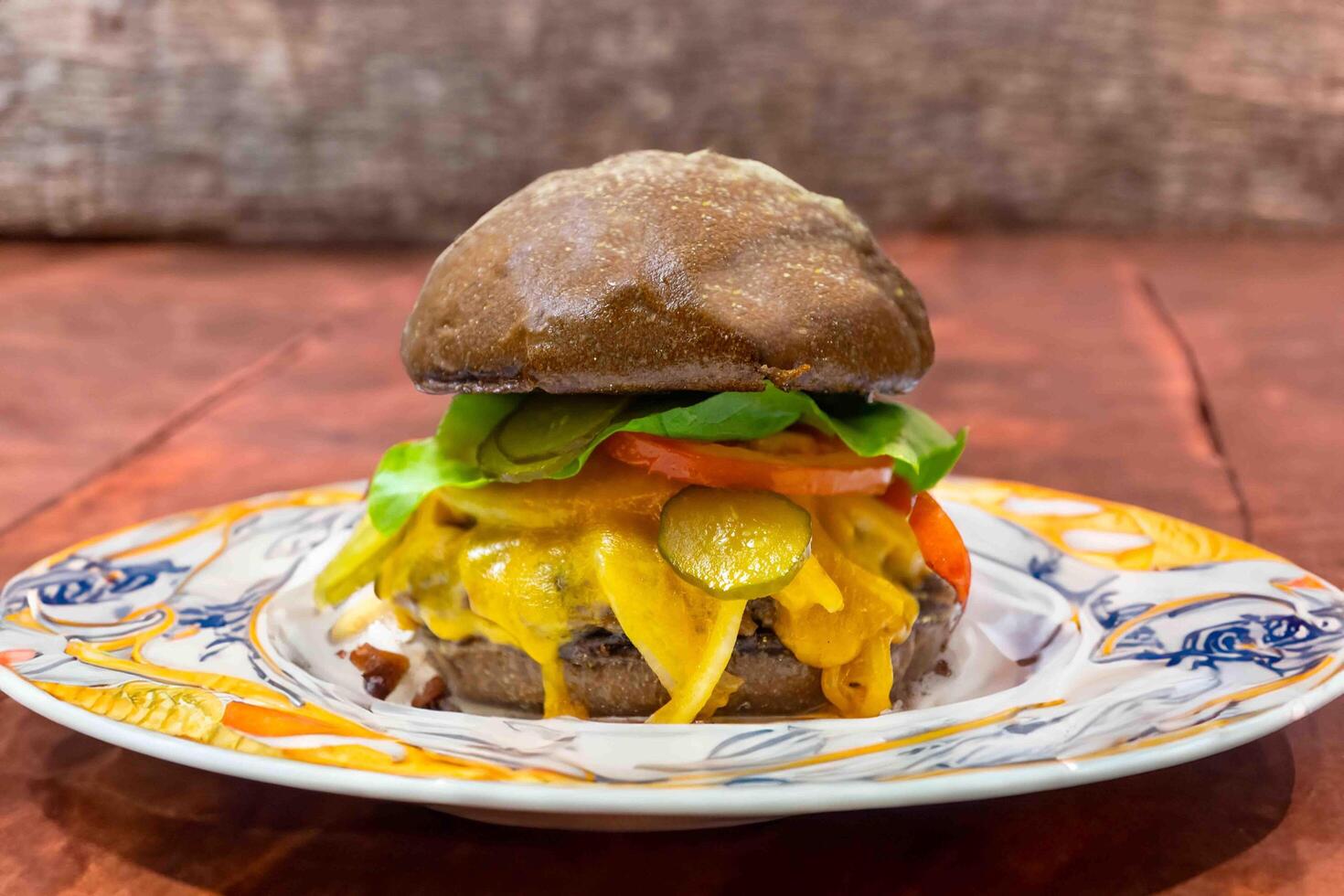 Traditional rustic burger sandwich with cheddar cheese, vegetables and Australian bread in creative photography and cozy village setting photo