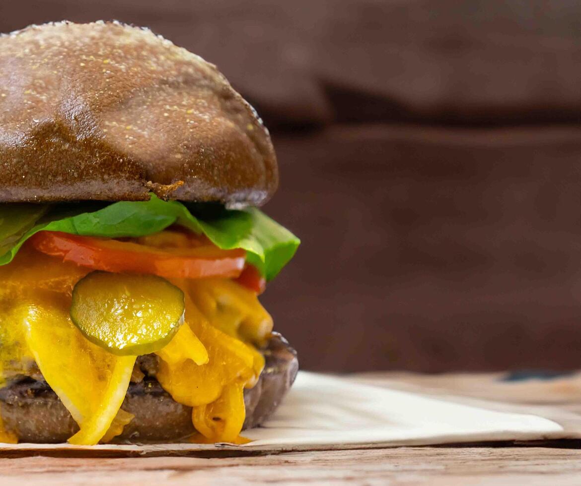 Traditional rustic burger sandwich with cheddar cheese, vegetables and Australian bread in creative photography and cozy village setting photo