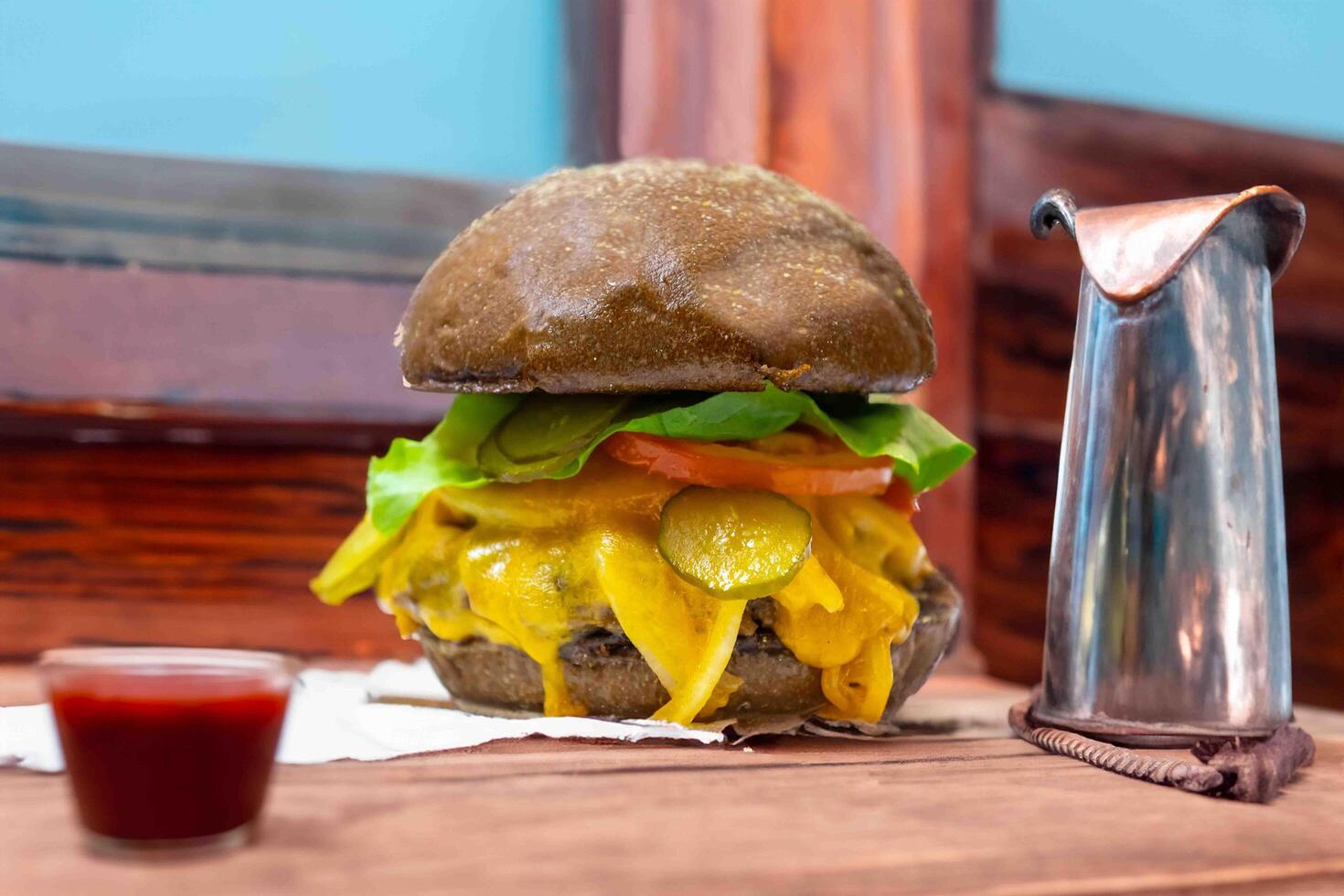 Traditional rustic burger sandwich with cheddar cheese, vegetables and Australian bread in creative photography and cozy village setting photo