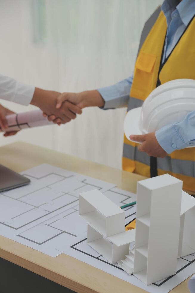 Construction and structure concept of Engineer or architect meeting for project working with partner and engineering tools on model building and blueprint in working site, contract for both companies. photo