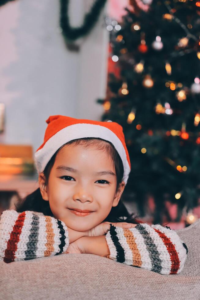 christmas, x-mas, winter, happiness concept - dreaming girl in santa helper hat photo