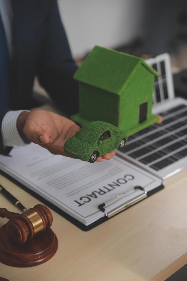 Auctioneer knocks down property sale by sample house and lawyer's gavel, judge mediates in property dispute in court car judge's gavel on wooden background Buying and selling real estate, housing photo