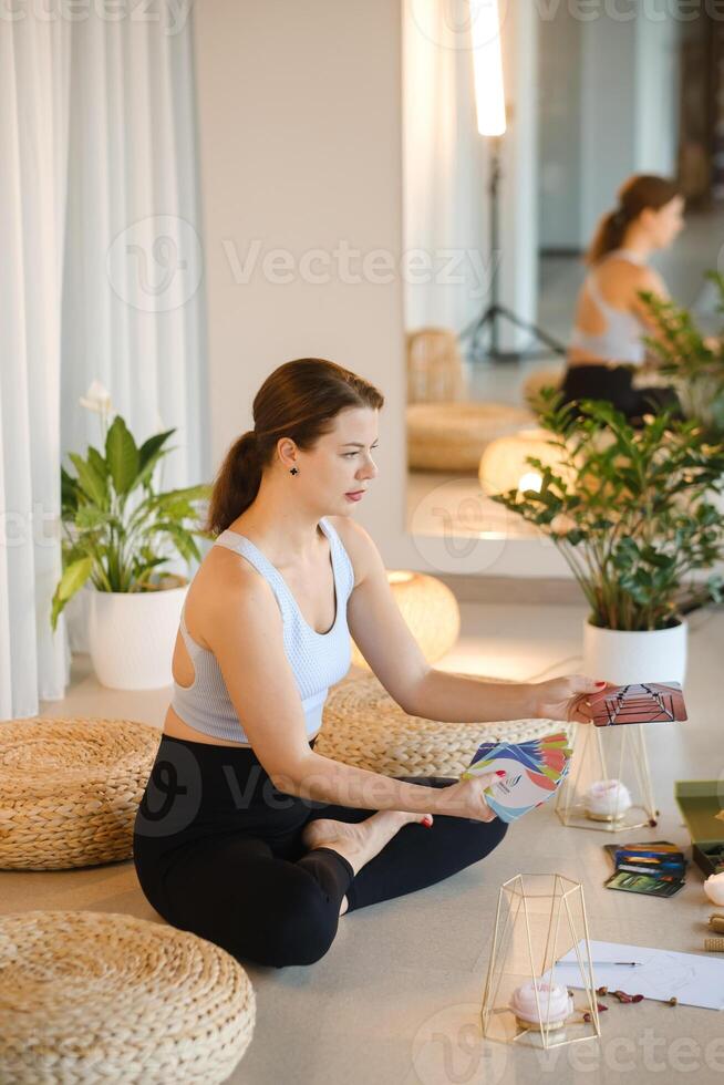 A sporty girl lays out Tarot cards indoors. Tarot cards in the hands of a fortune teller photo