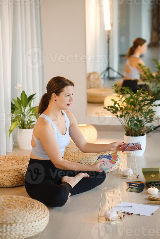 A sporty girl lays out Tarot cards indoors. Tarot cards in the hands of a fortune teller photo
