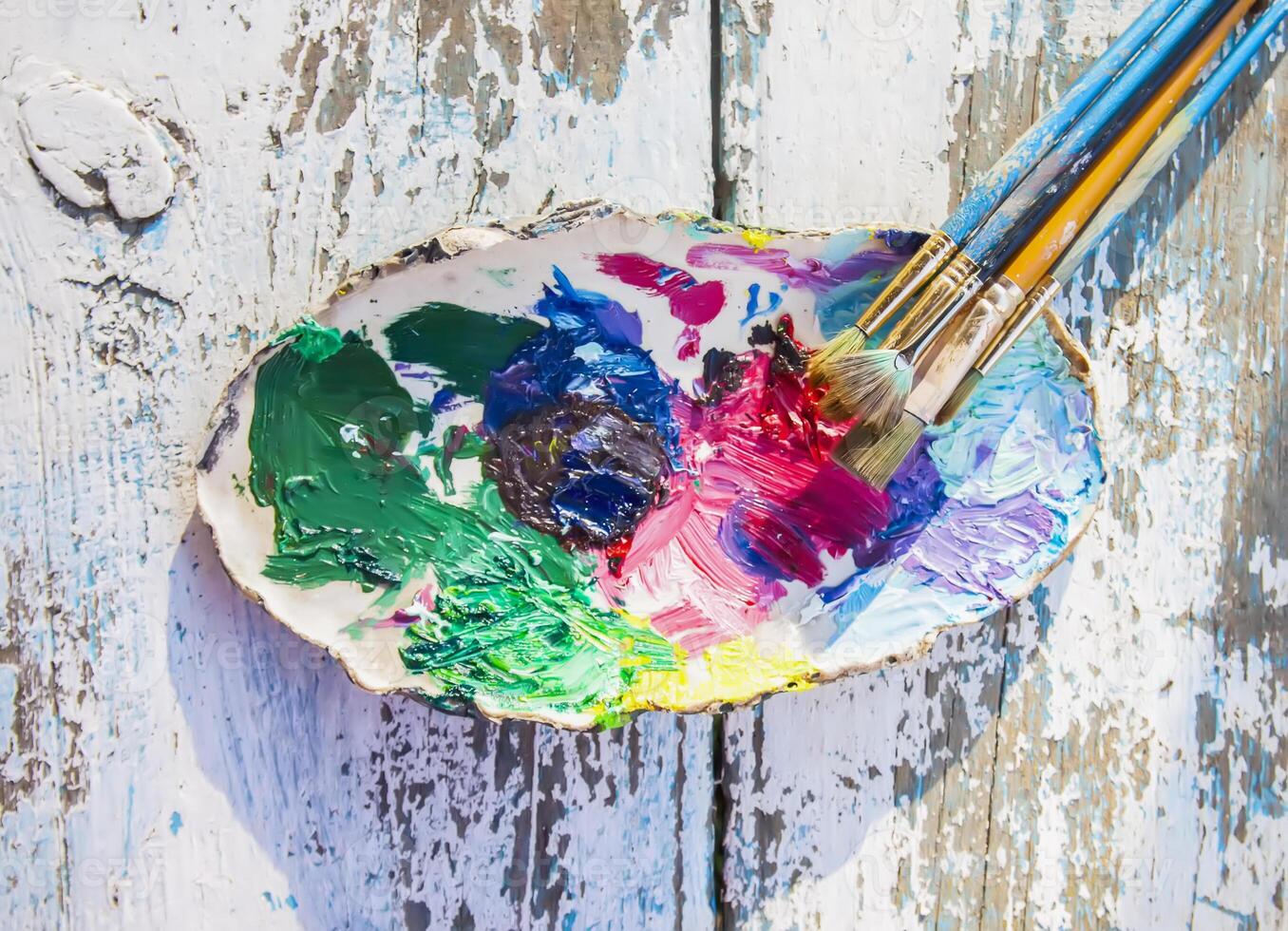 Oil paints and brushes on the old wooden table photo