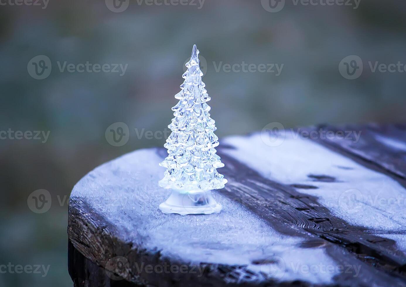 Glass toy luminous Christmas tree outdoors. photo