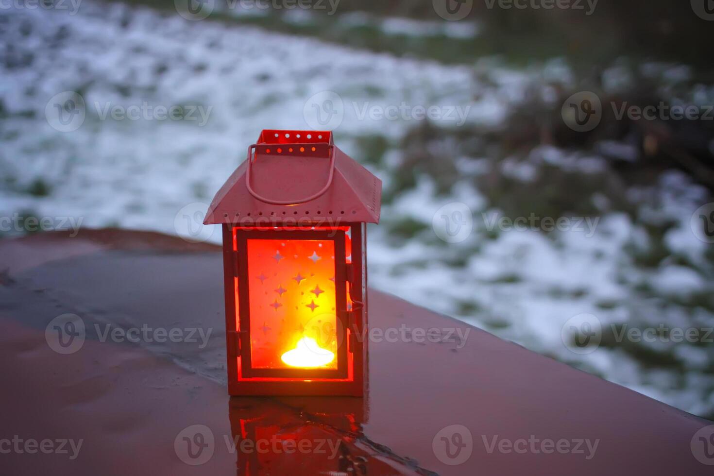 Decorative lantern with burning candle in autumn park at evening. photo