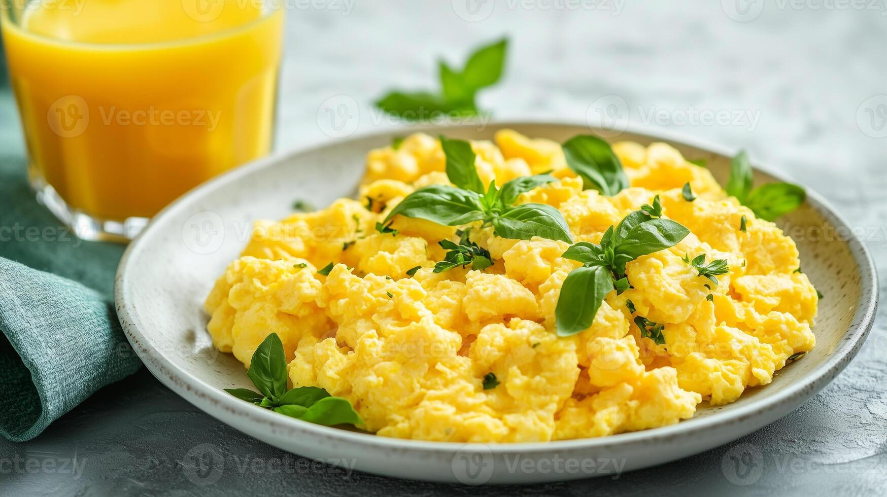 Large portion of scrambled eggs on a plate, placed beside a glass of juice, food photography photo