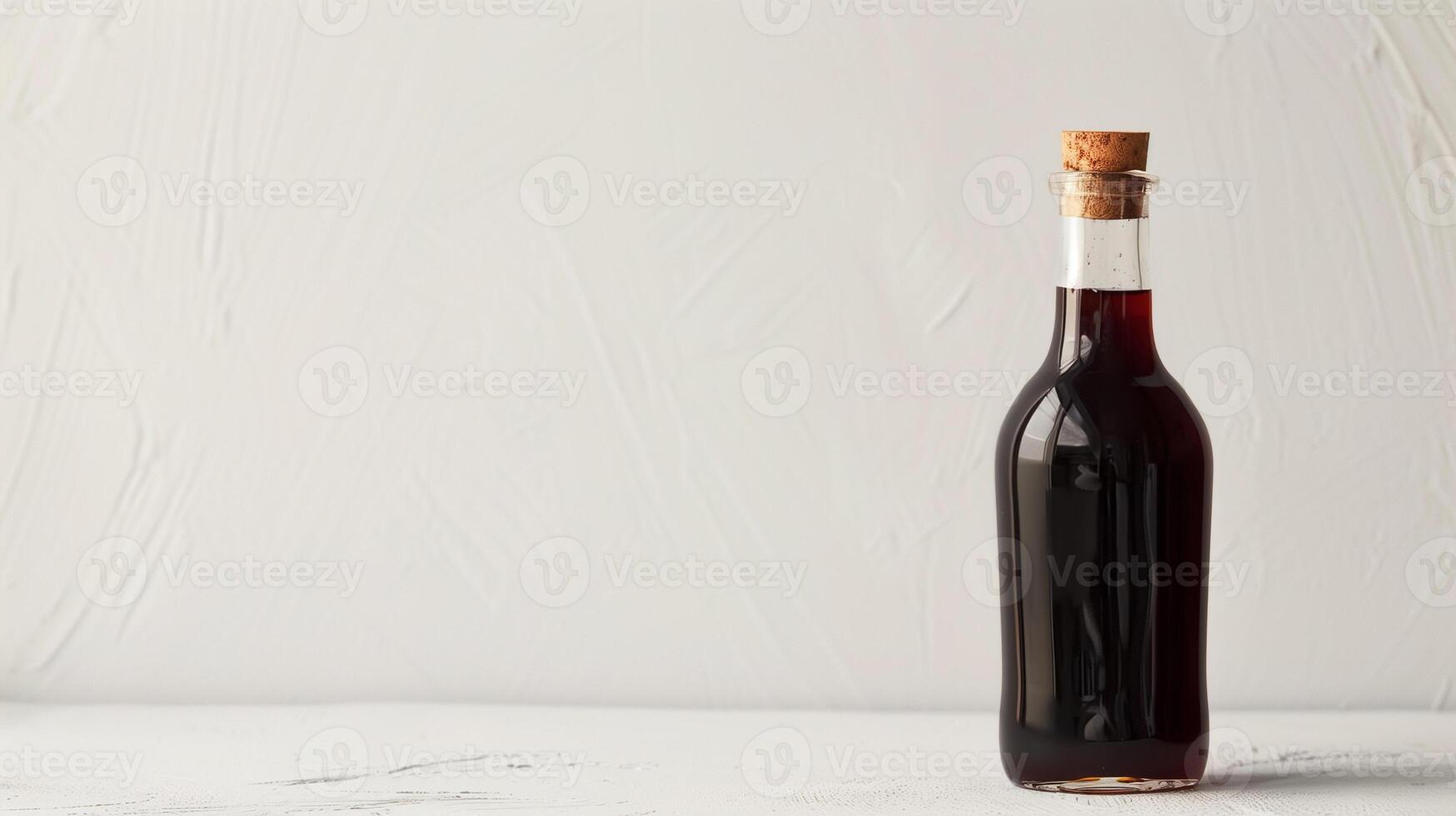 Narrow, tall glass bottle holds a dark syrup, positioned on a plain white surface, gastronomy photography photo