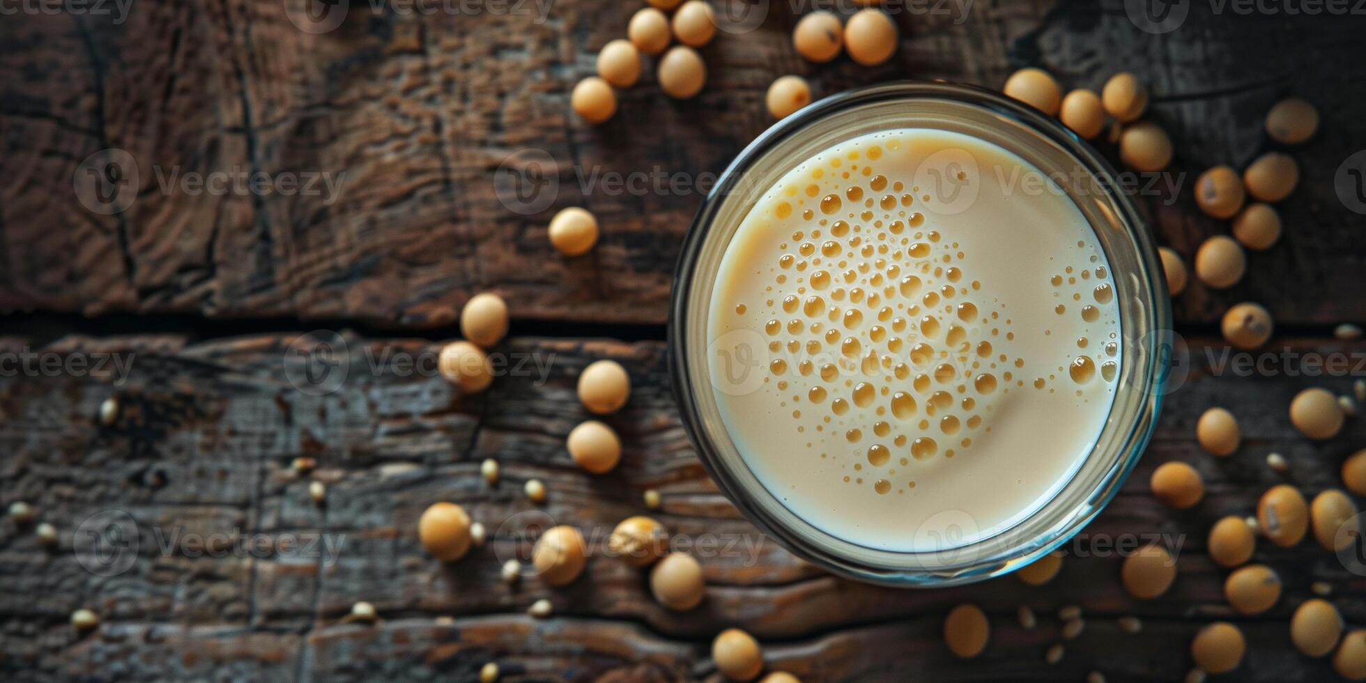 Glass of soy milk with soybeans scattered on rustic wooden surface, food setting photo
