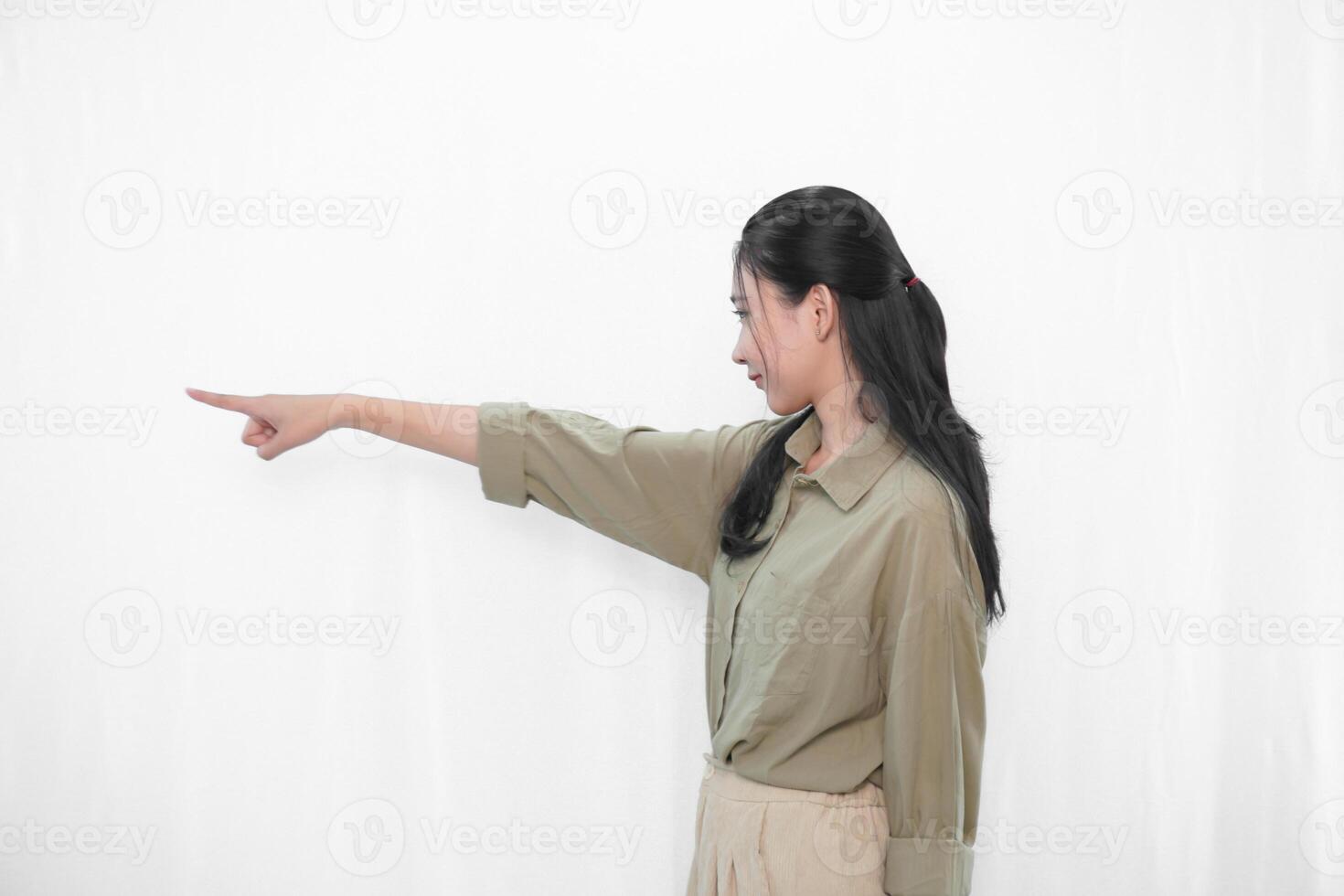 The expression of a smiling and pointing forward Indonesian Asian woman in green clothes from photo