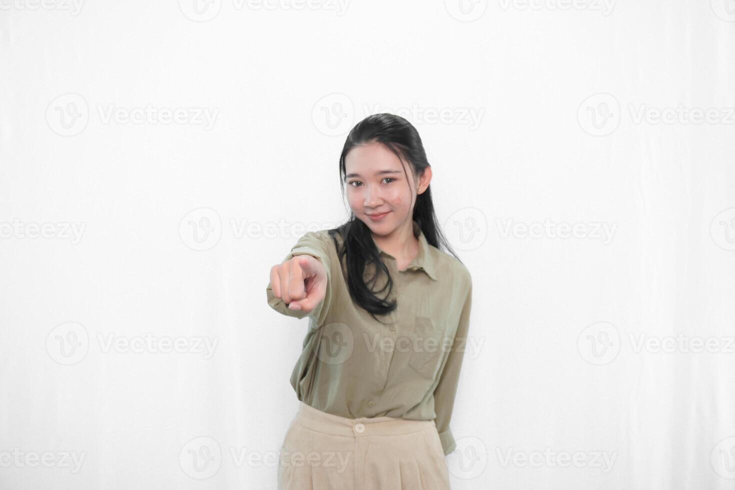 The expression of a smiling and pointing forward Indonesian Asian woman in green clothes from photo