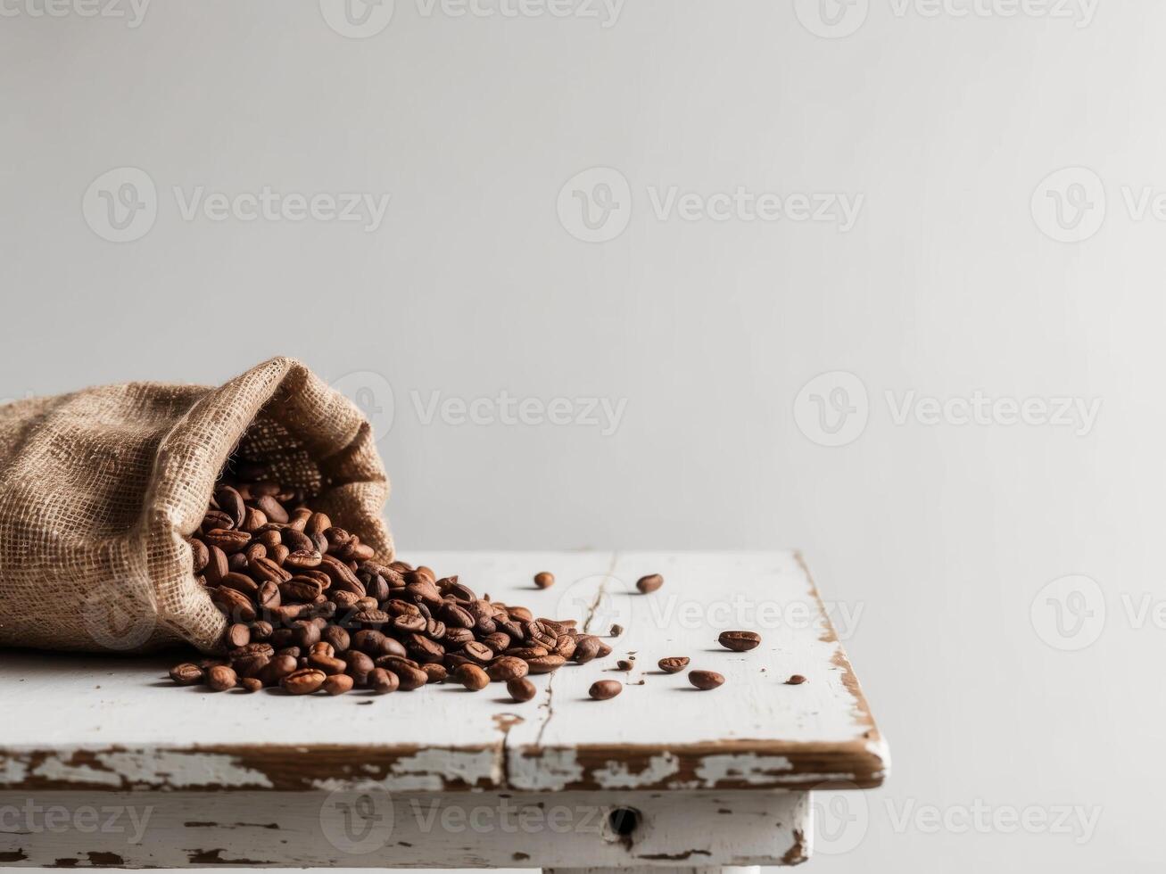 Cocoa beans spilling from a burlap sack on a rustic wooden table. photo