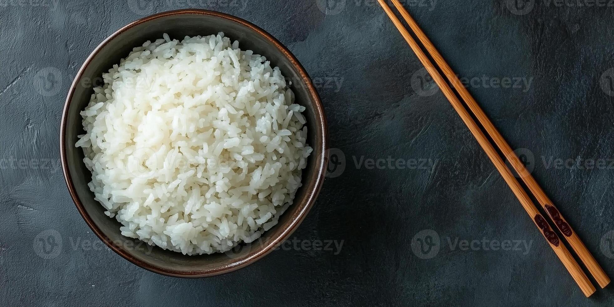 Bowl of steamed white rice with wooden chopsticks on the side, photorealistic food photo