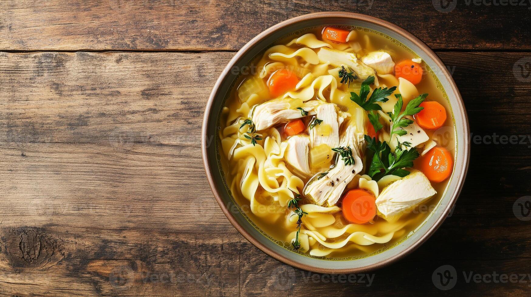 Chicken noodle soup in a shallow bowl with submerged ingredients, meal photography photo