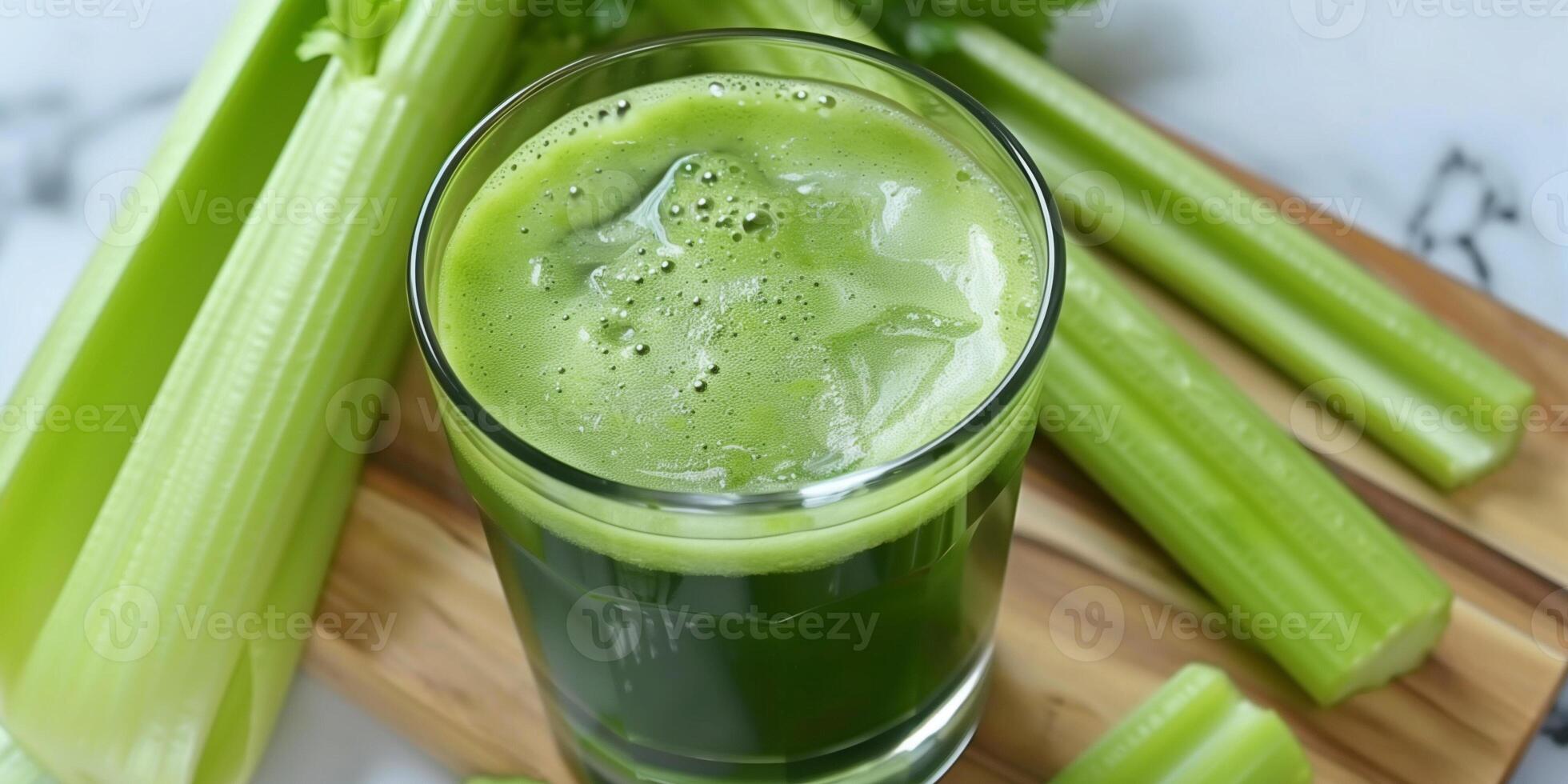 Clear glass of cold-pressed celery juice placed on a cutting board, with celery stalks surrounding it, food photography photo
