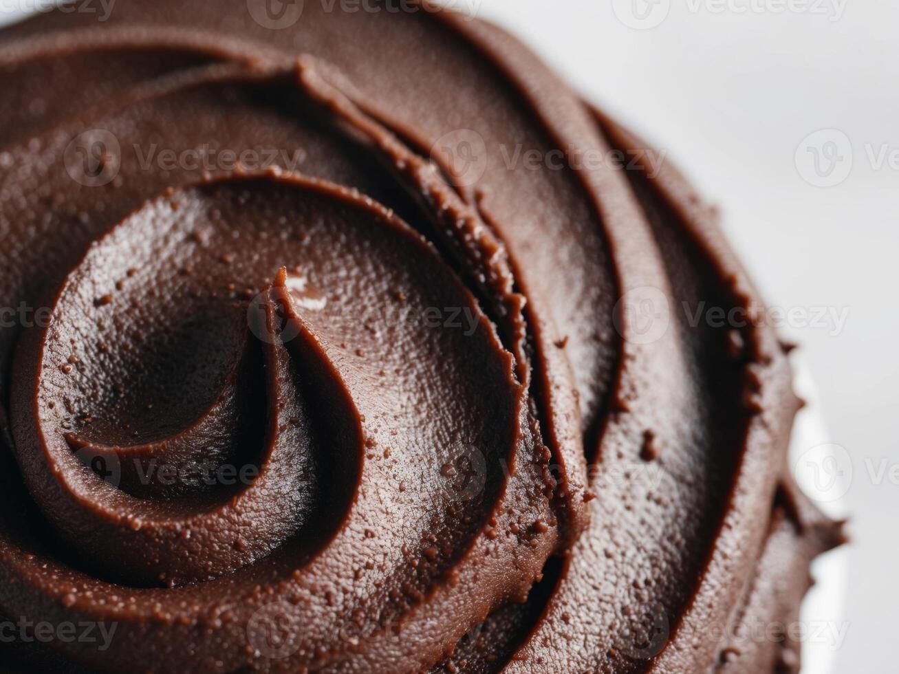 close up image of dark brown chocolate frosting with rough textured surface. photo