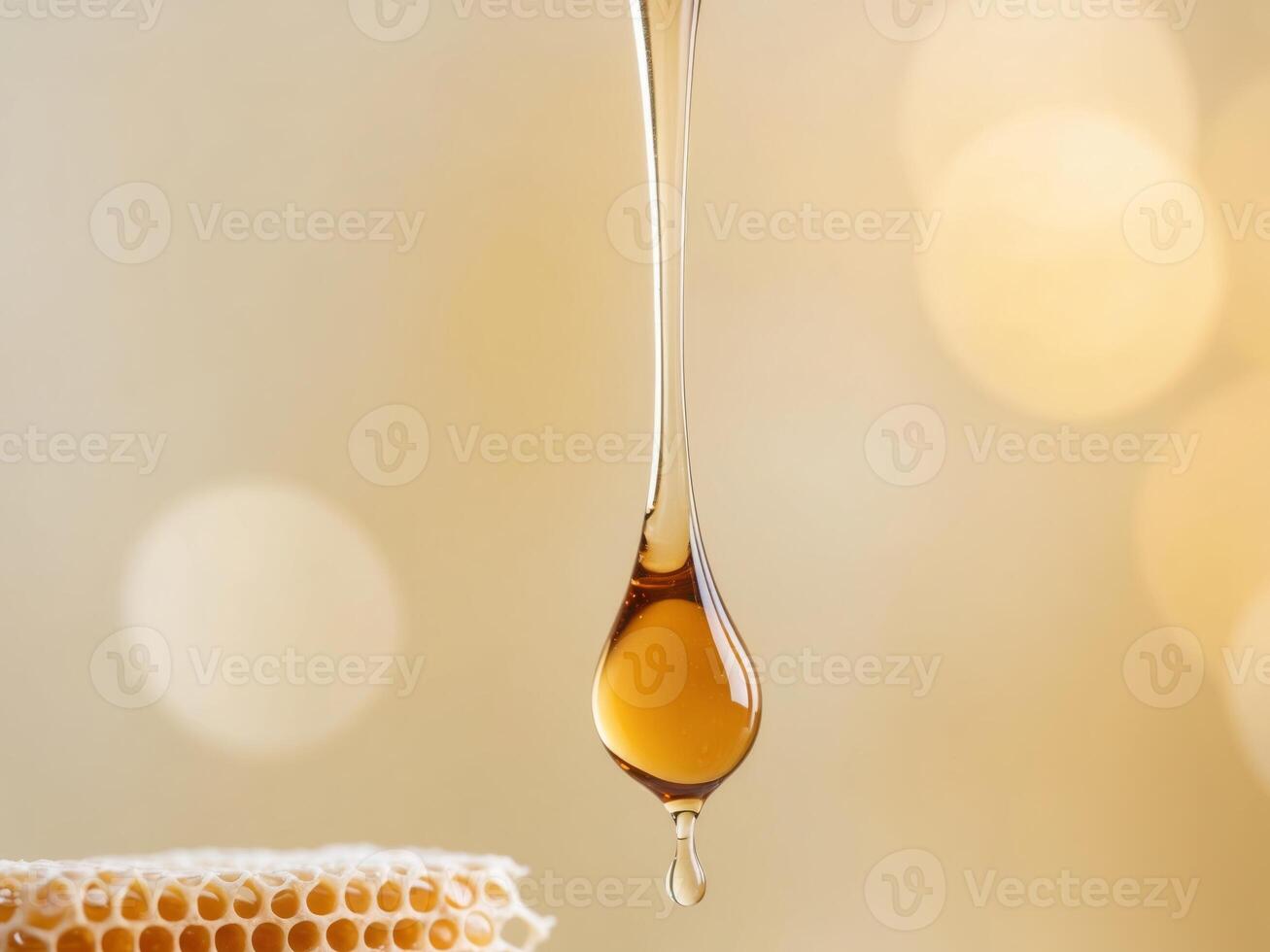 Honey is dripping from a honeycomb with a golden light background. photo