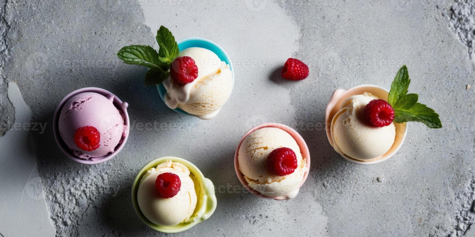 Colorful scoops of ice cream with fresh raspberries and mint on a textured gray surface. photo