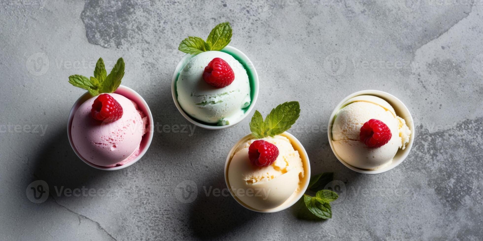 Colorful scoops of ice cream with fresh raspberries and mint on a textured gray surface. photo