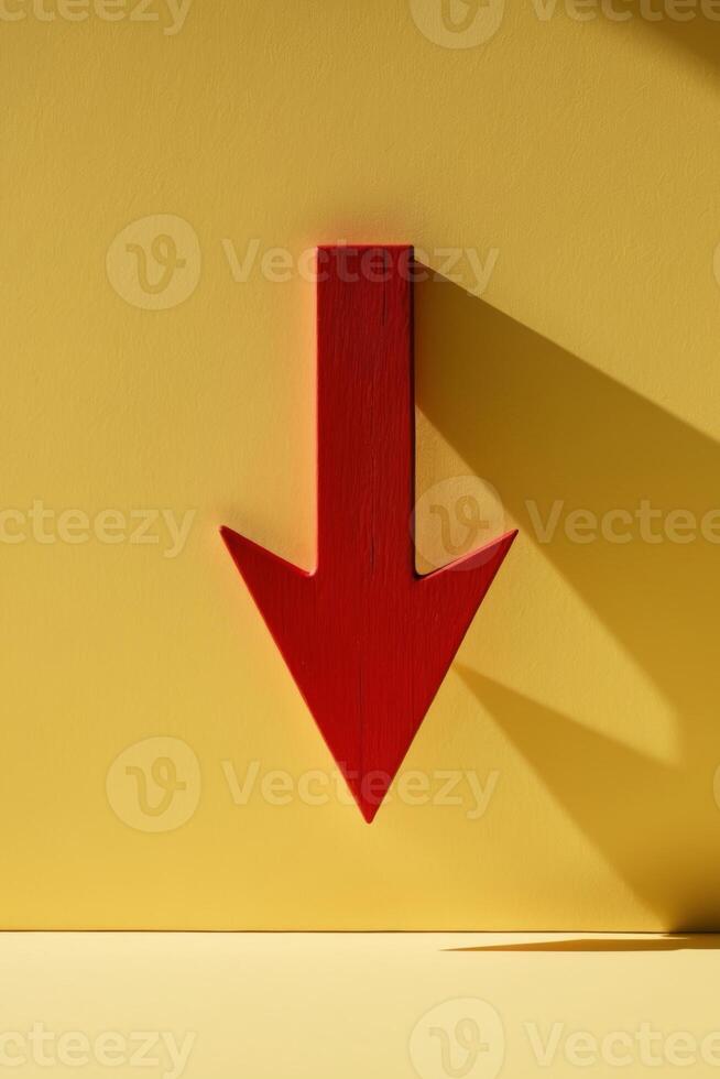 red wooden arrow pointing down on yellow background business market decline or economic. photo