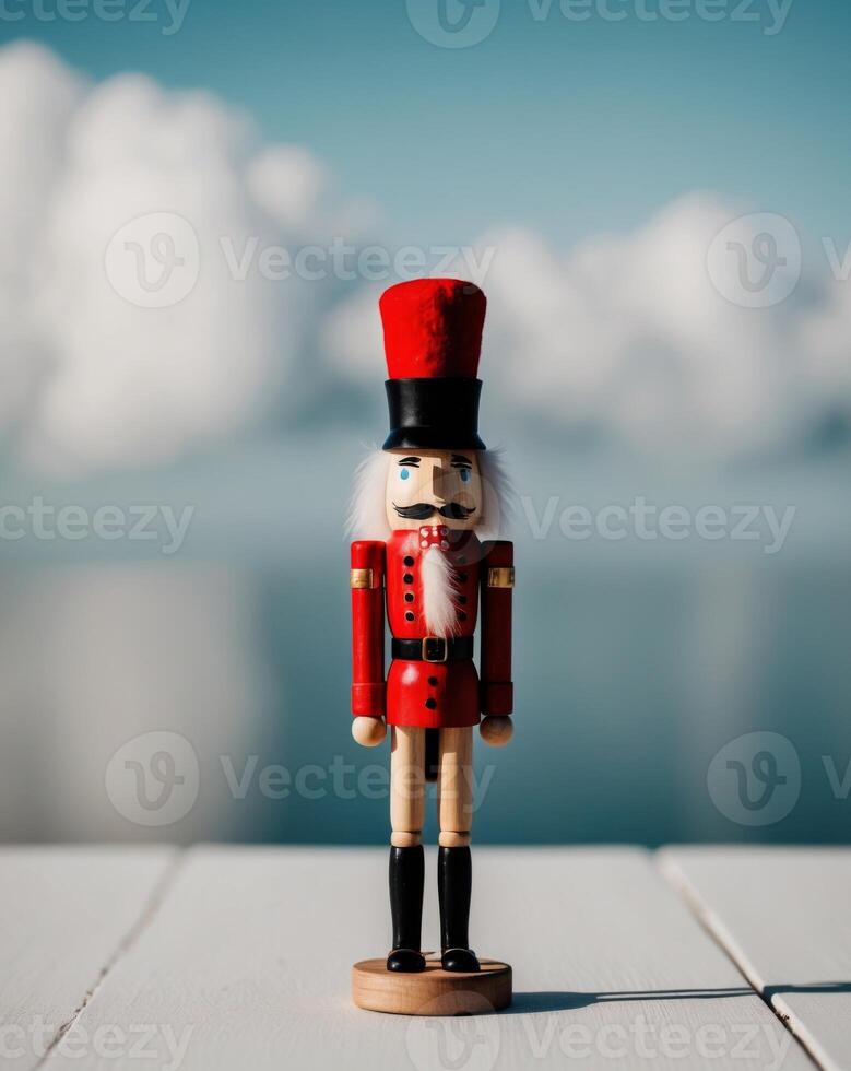A wooden nutcracker with a red hat stands in front of a blue background. photo