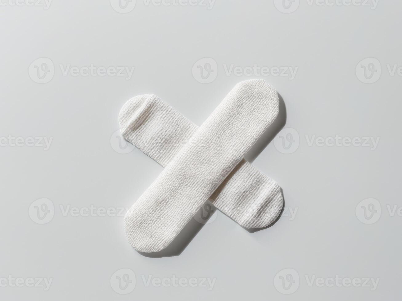 Two adhesive bandages are crossed over each other. photo