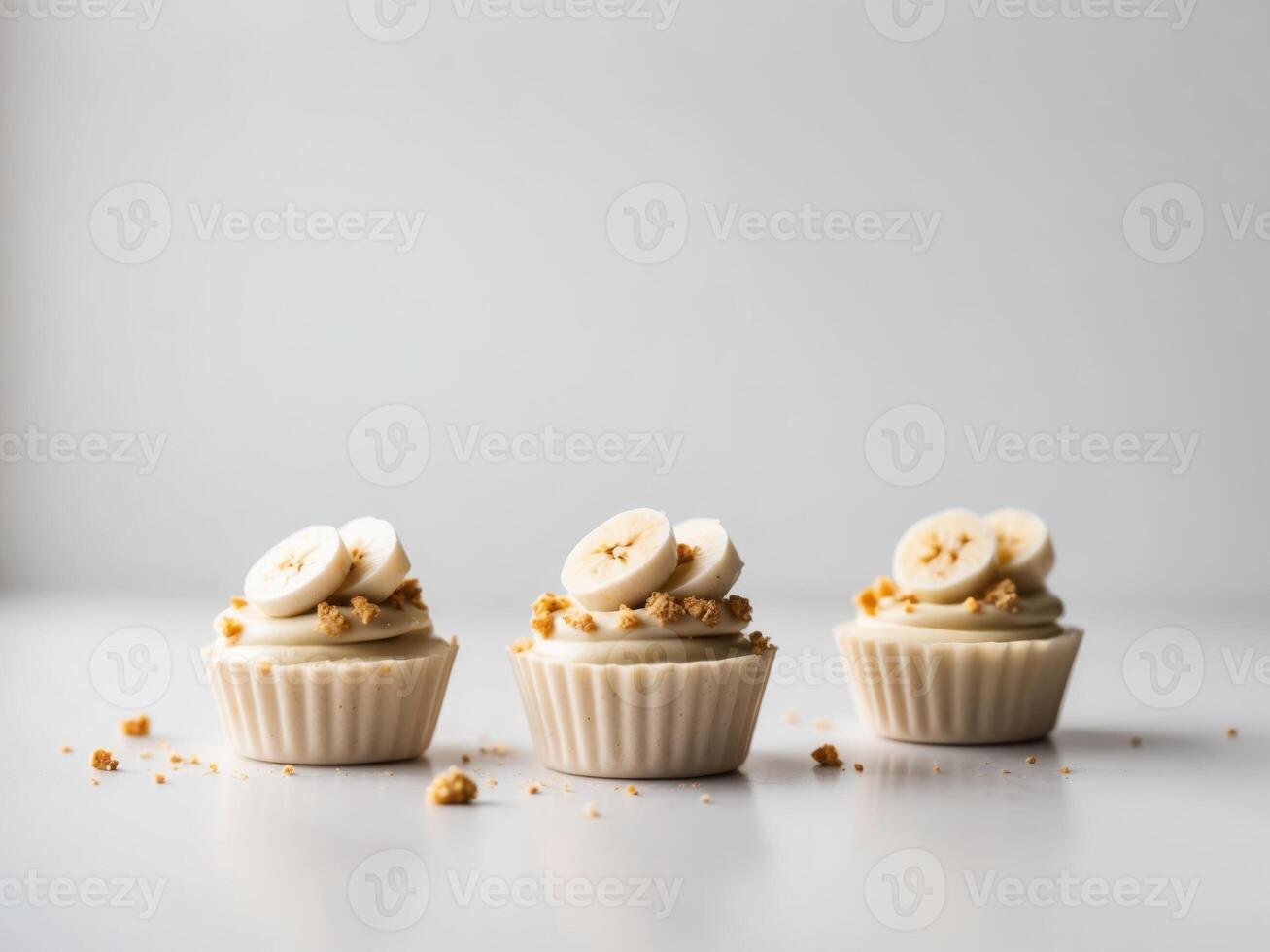 Three delightful banana cream treats garnished with sliced bananas and crumbs. photo