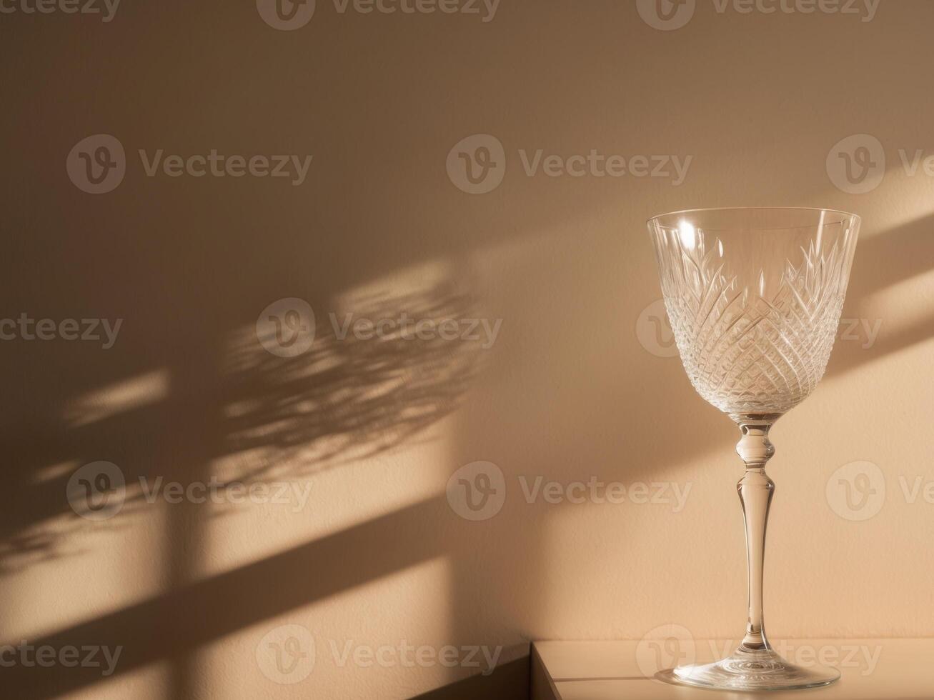 Elegant Crystal Glass Casting Intricate Shadows on a Warm Beige Wall During the Golden Hour. photo
