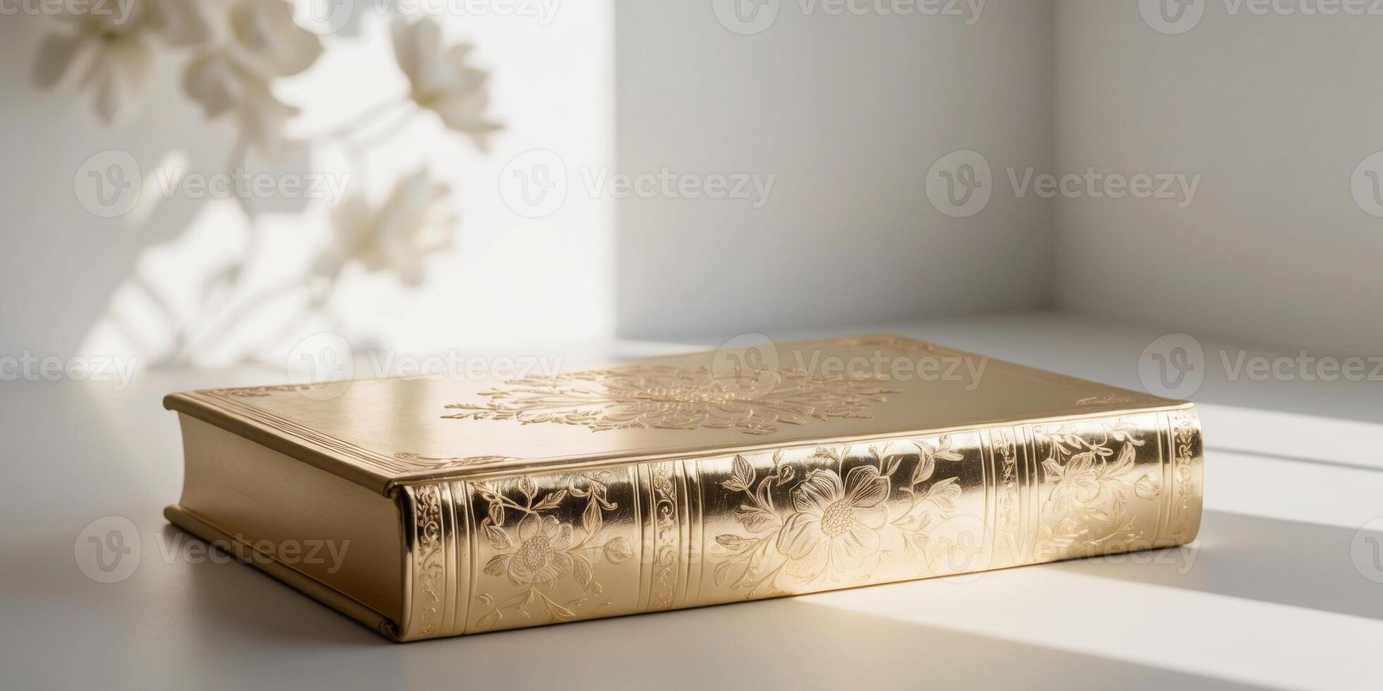 A gold leafed book with a floral design on the cover. photo