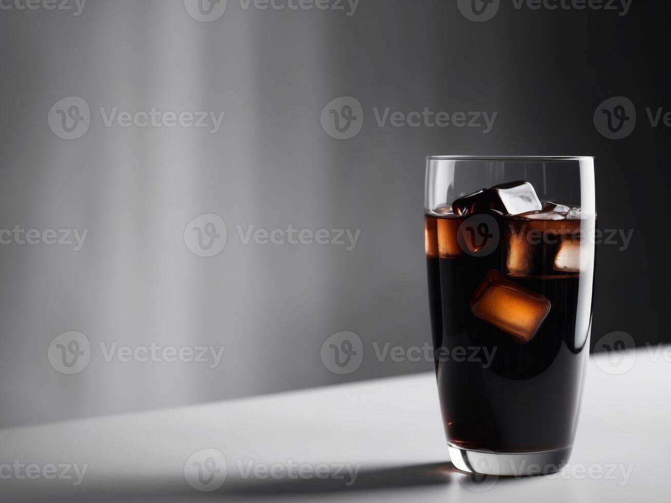 Glass with dark soda and ice with blurred background. photo