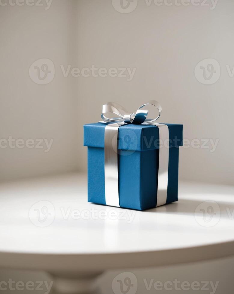 A blue gift box with a silver bow on top. photo